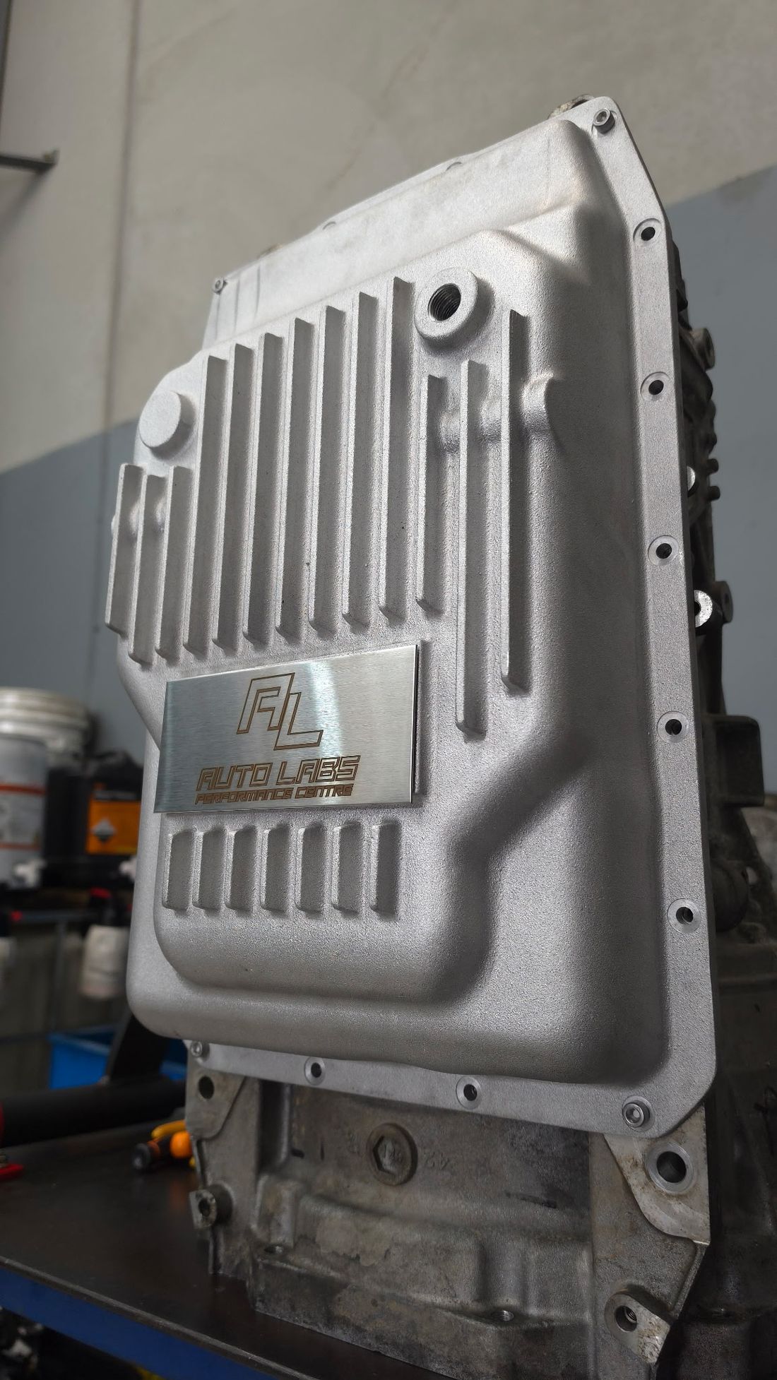 The Auto Labs 10R80 deep cast aluminium transmission pan fitted to a 10-speed transmission — external cooling fins, temp sender port and etched AL plate
